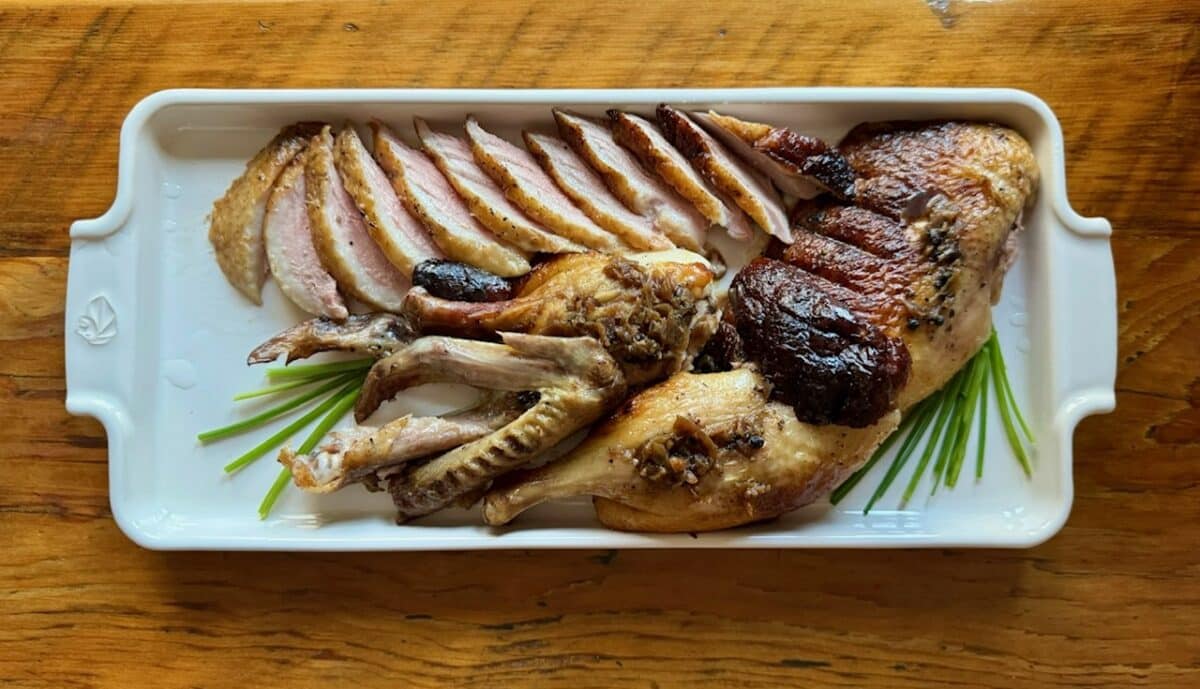 Roast duck with peppercorns on a whie platter