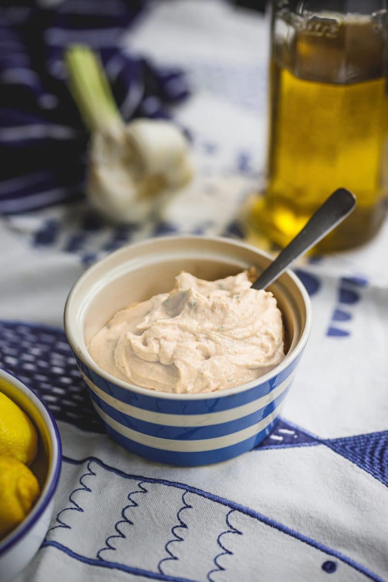 Creamy aioli sauce in a blue striped bowl