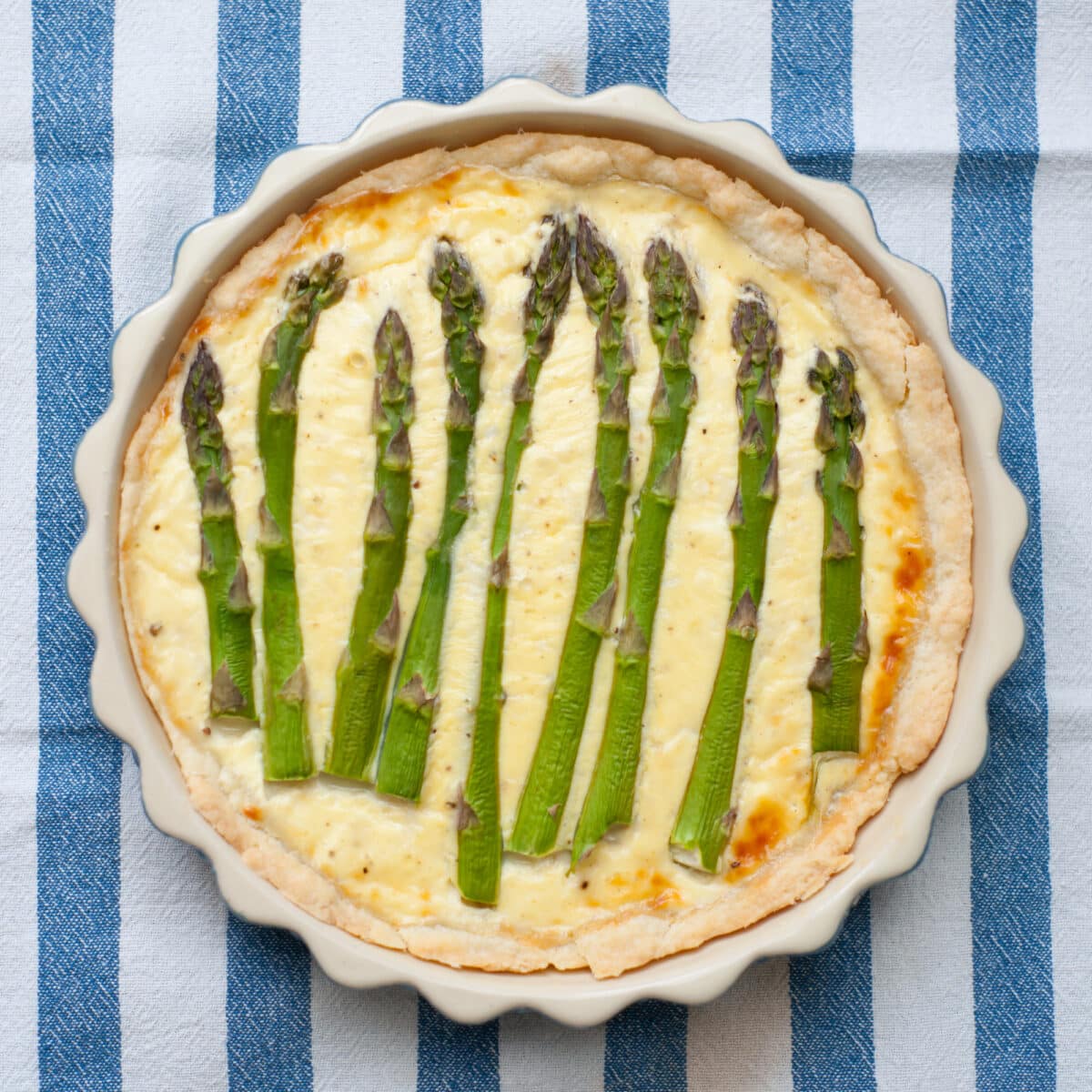 classic asparagus quiche on a striped cloth