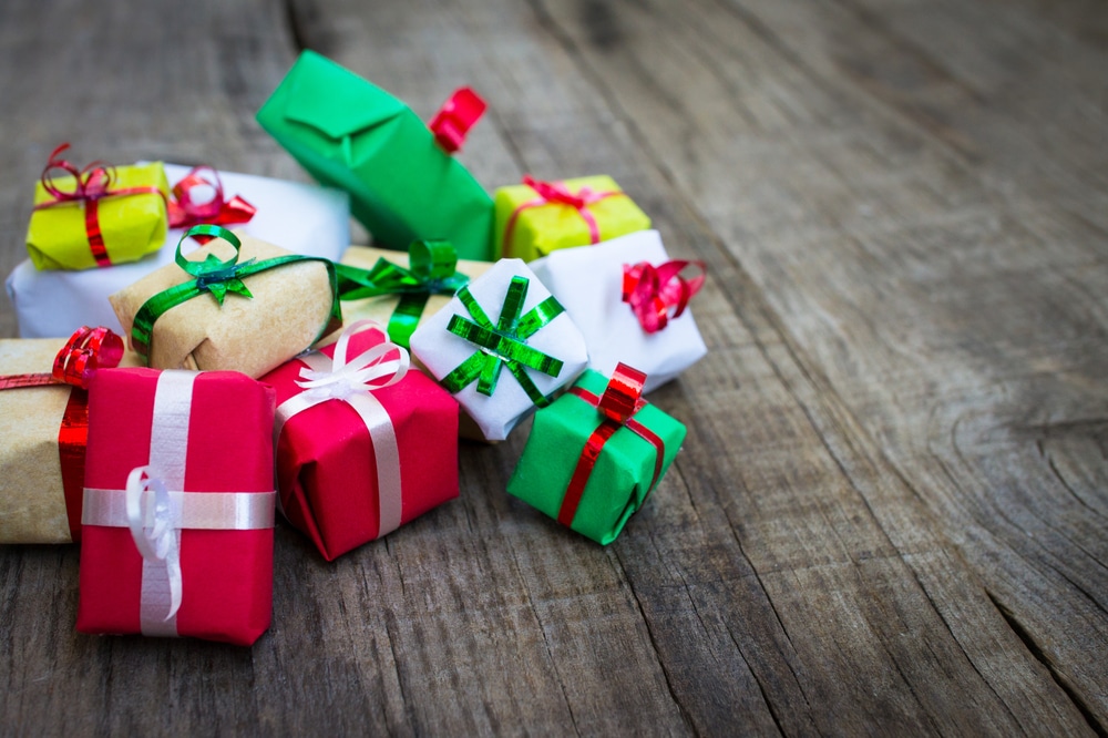 Colorful gift packages tied with ribbons on a wooden surface