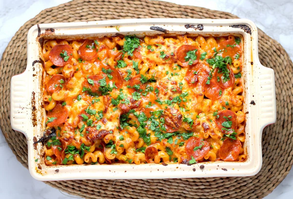 Baked pasta with cheese, tomato, and meat in a casserole dish