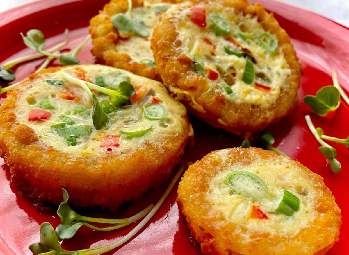 Fried onion rings with eggs, garnished with green peppers and sprouts