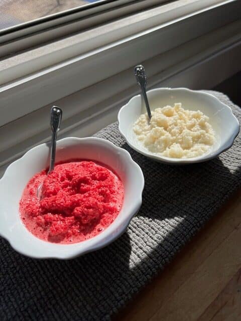 Two bowls of food by a window.