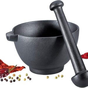 Black cast iron mortar and pestle with spices around it