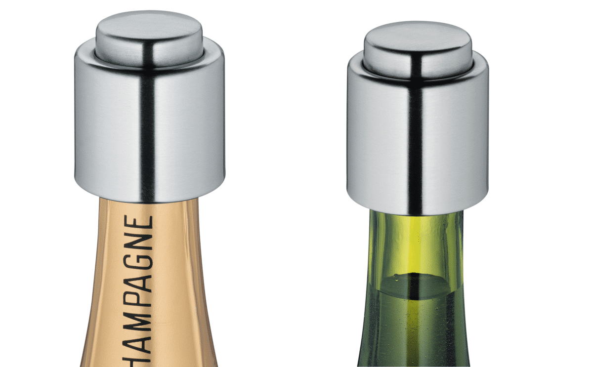 Close-up of stainless steel champagne and wine sealers on top of bottles.