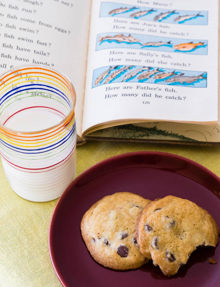 Open children's book showing illustrated fish with a glass of milk.