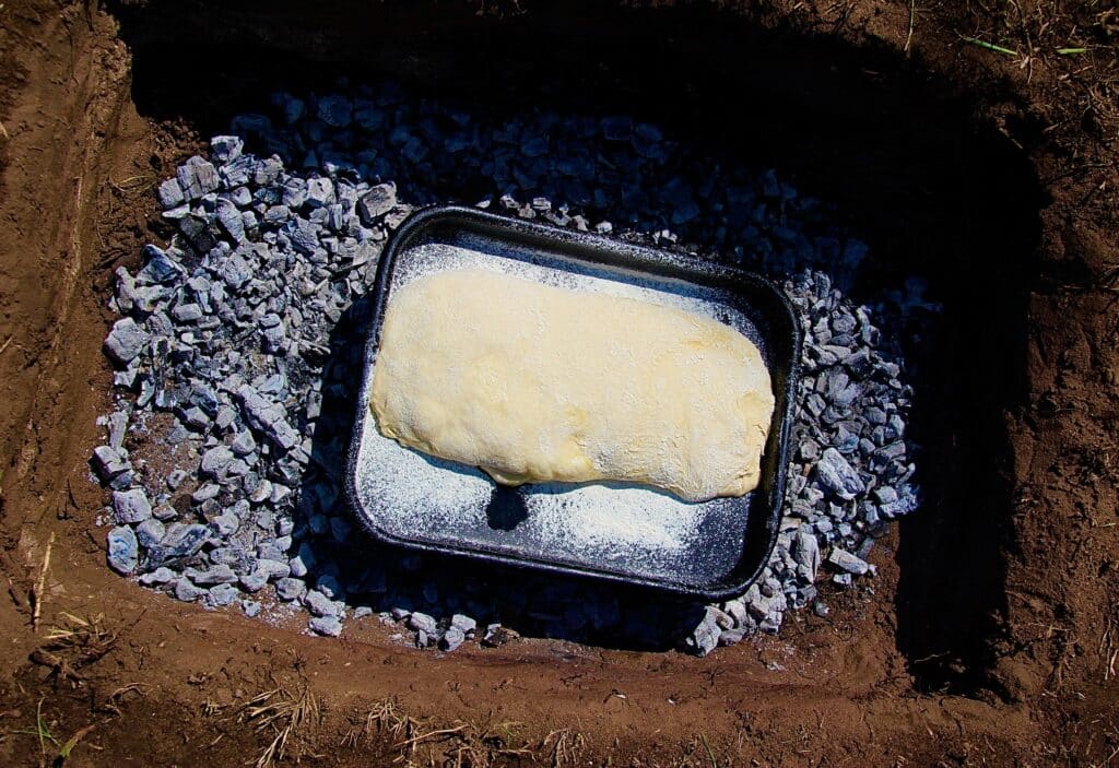 Ciabatta bread ready to be cooked in a 'bush' oven over a circle of fire