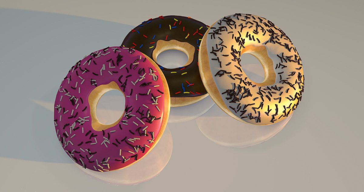 Three vibrant doughnuts with different toppings and sprinkles