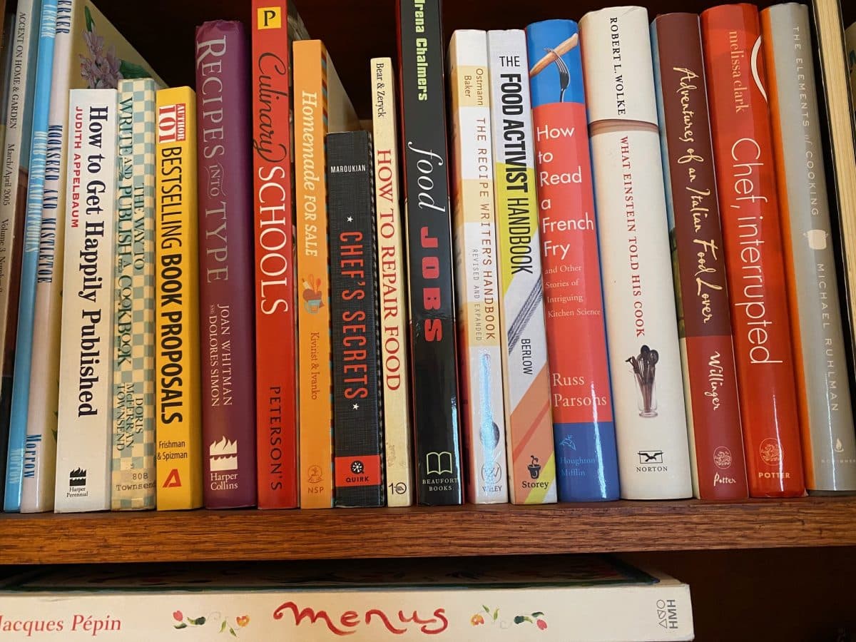 A collection of cookbooks on a shelf.