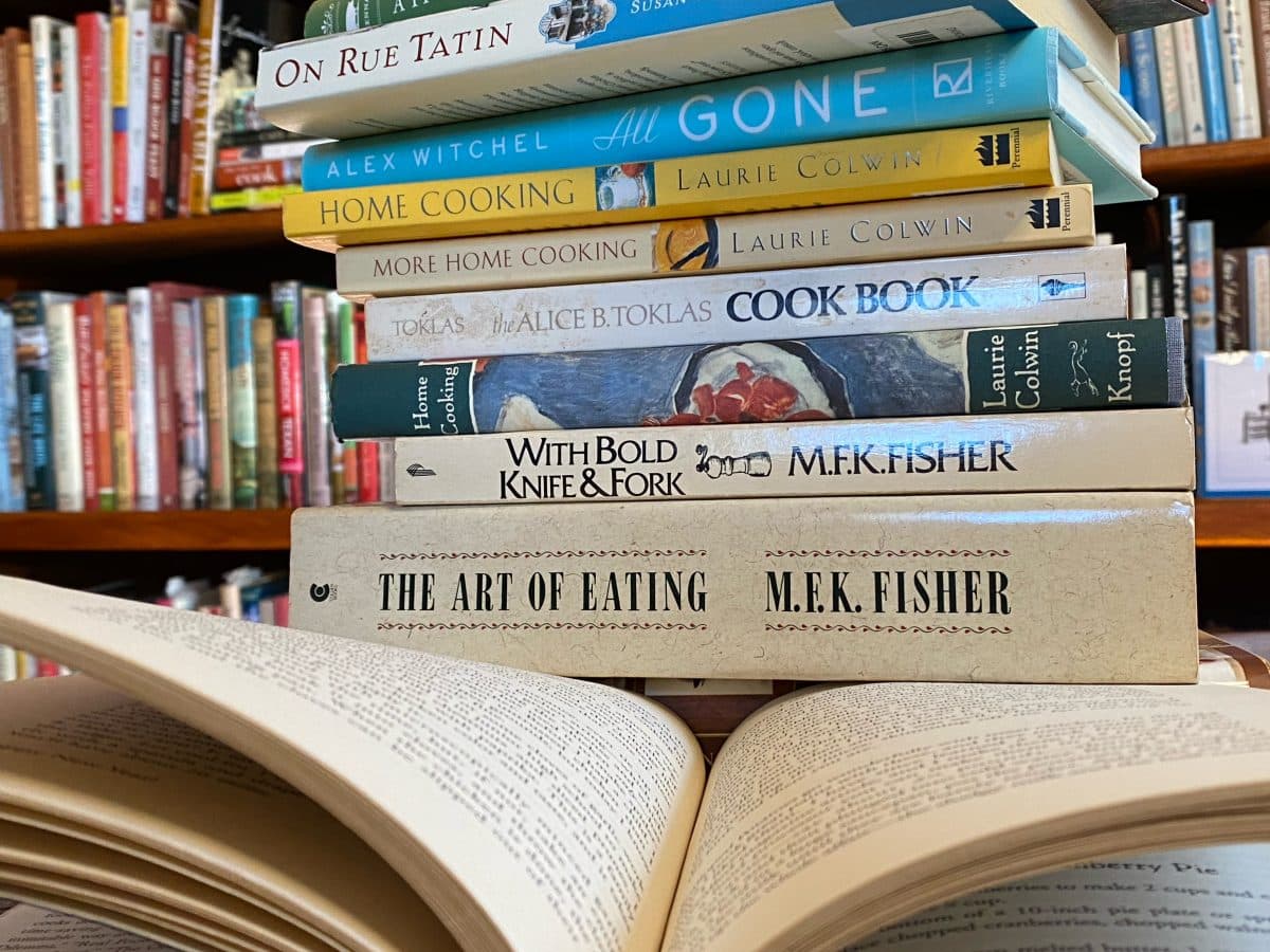 Stacks of cookbooks showcasing their spines with visible titles.