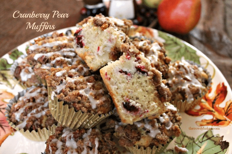 Muffin cut in half revealing cranberries and pear chunks inside.