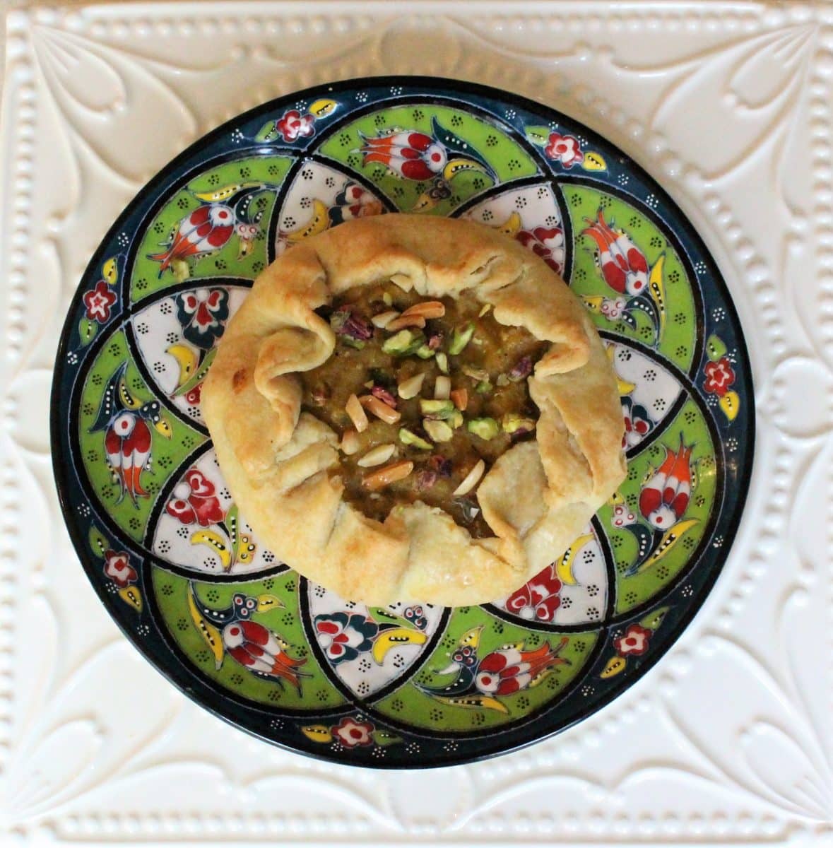 Close-up of Daar ni Pori pastry garnished with nuts.