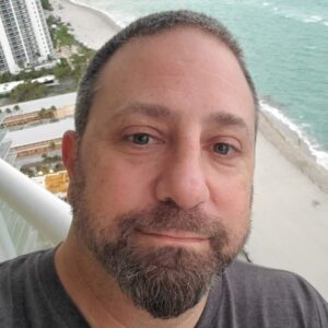 Close-up headshot of David LaForce with ocean backdrop
