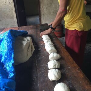 Hands cutting a strip of dough
