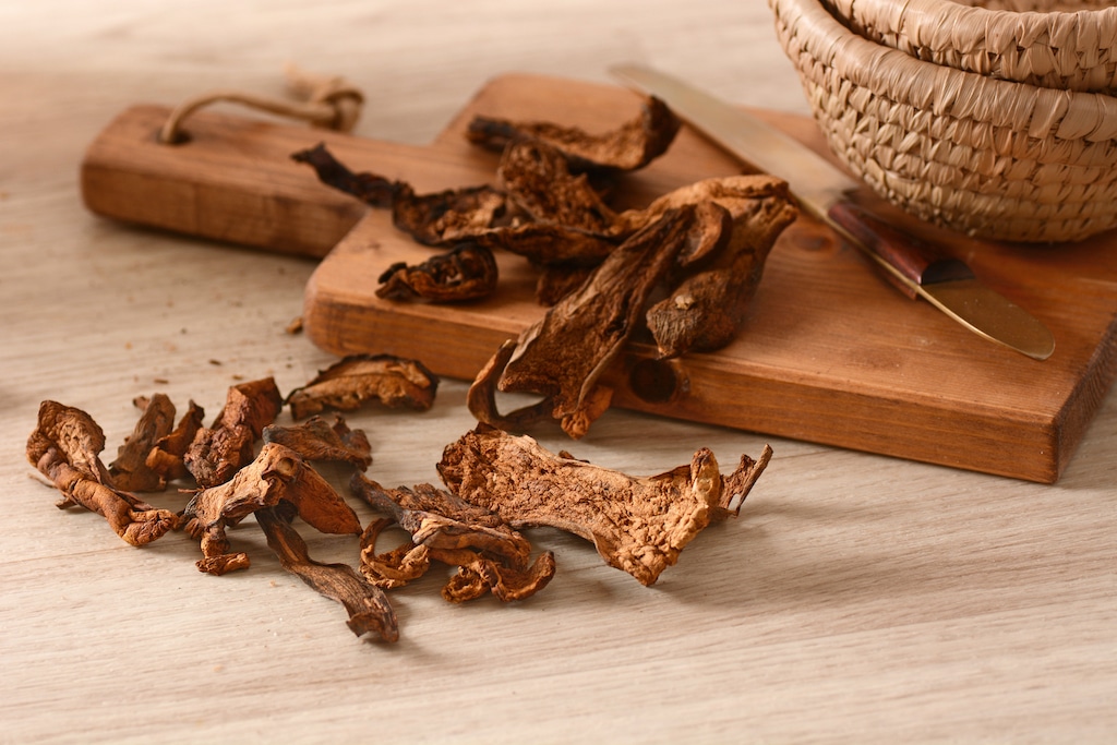 Close-up of dried porcini mushrooms on a wooden cutting board.