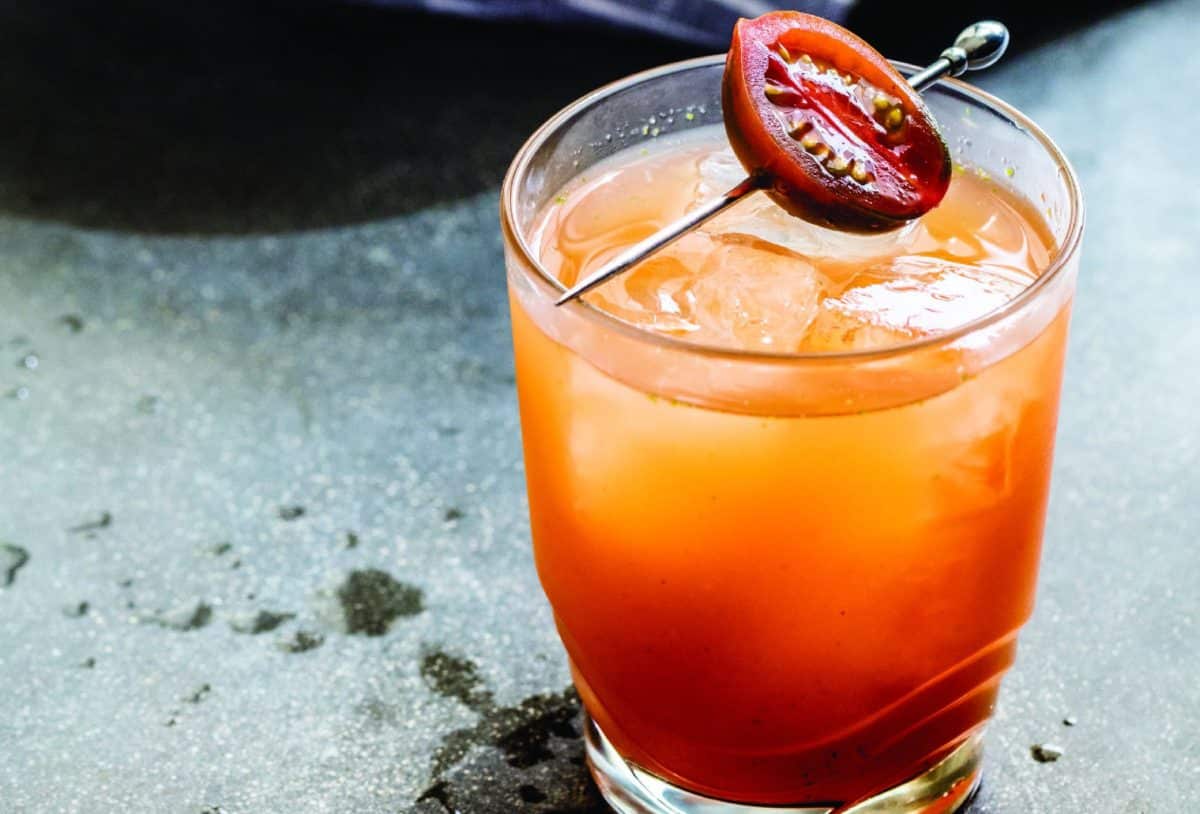 Close-up of an El Gallito cocktail with a slice of tomato garnish.
