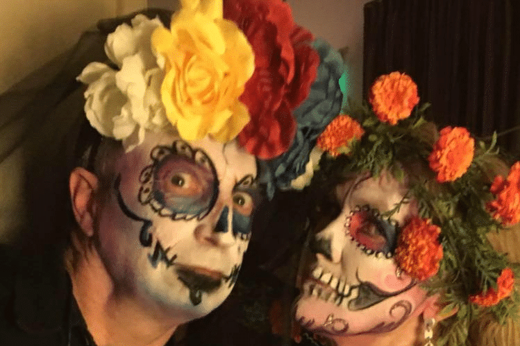 A woman hugging a young boy and girl against a backdrop of a serene lake and trees.
