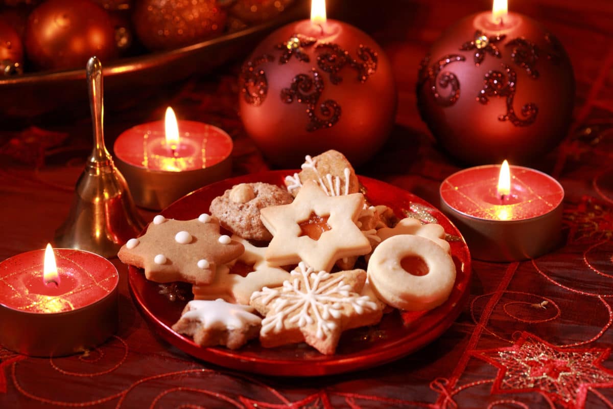 Assorted Christmas cookies and decorations with lit candles