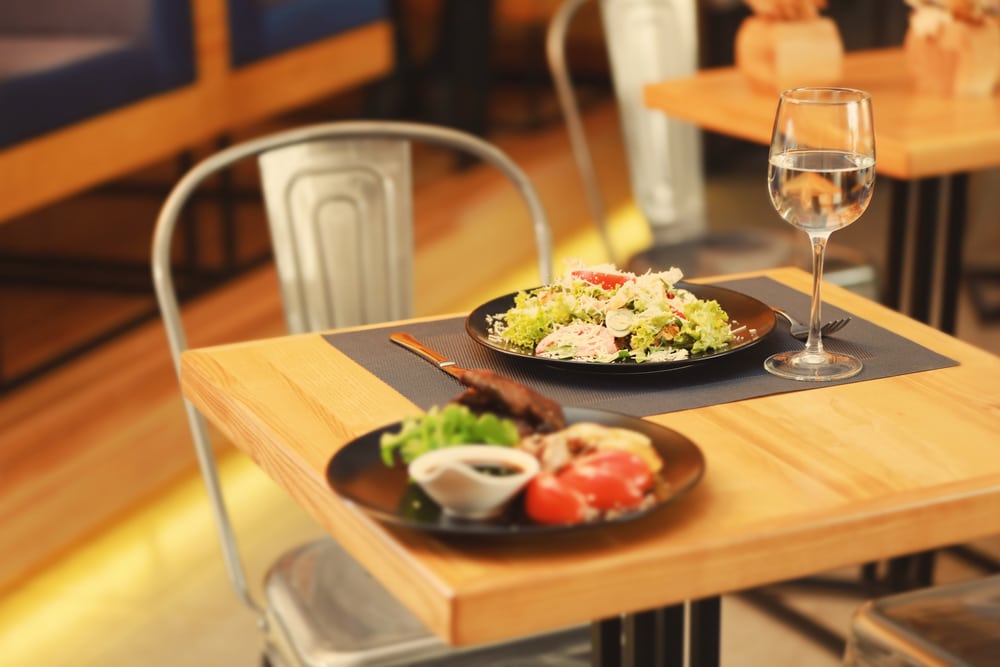 Gourmet dishes presented on a wooden table in a well-lit restaurant setting.