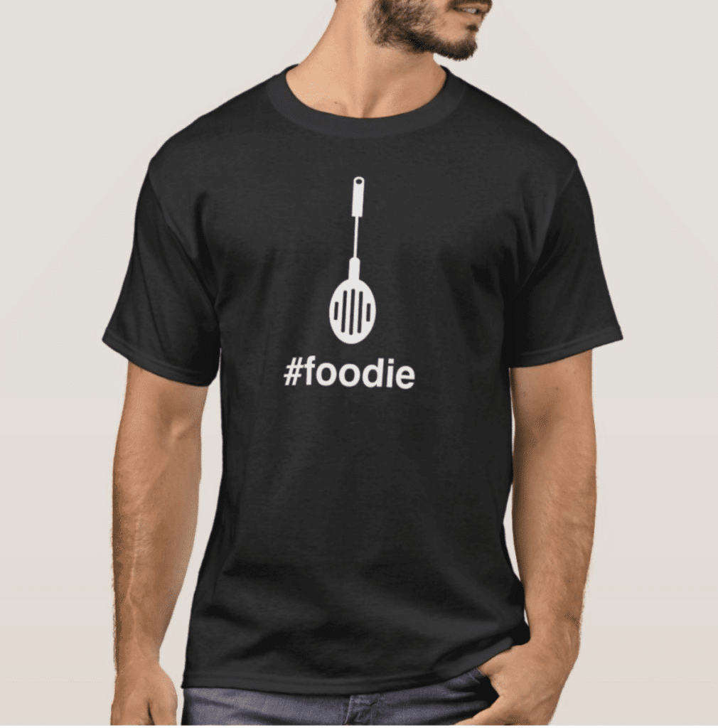Man wearing a black t-shirt with a spatula graphic and the hashtag 