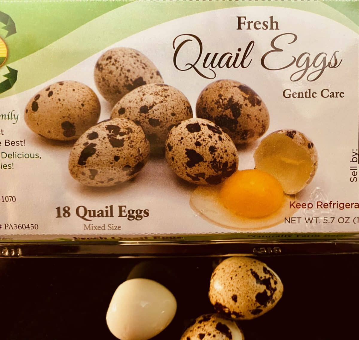 Packaged fresh quail eggs with one broken revealing yolk