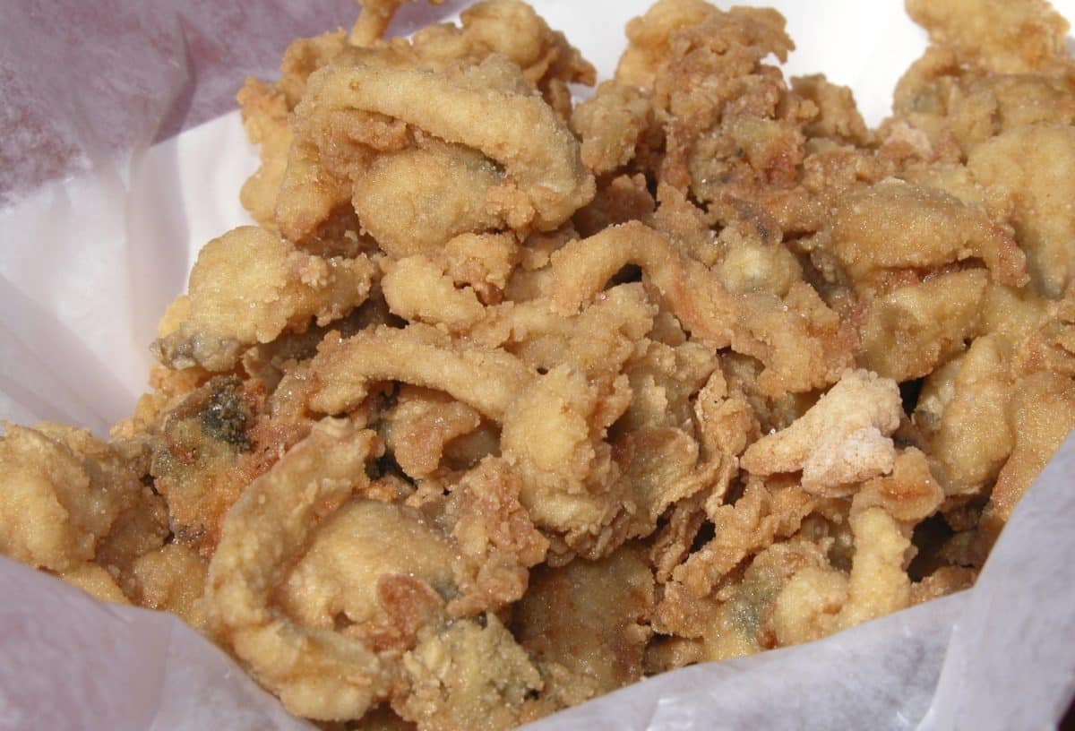 Basket filled with golden brown fried clams.
