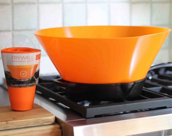 A Frywall silicone shield on a frying pan preventing food splatters.
