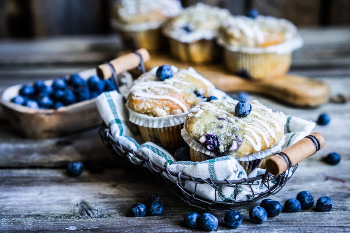 Fresh blueberry muffins in a rustic setting with a checkered cloth.