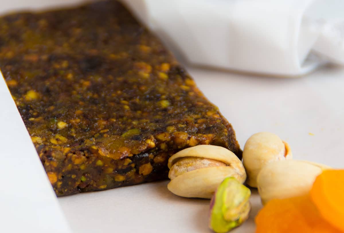 Close-up of dark-colored, gluten-free snack bars with nuts and dried fruits.
