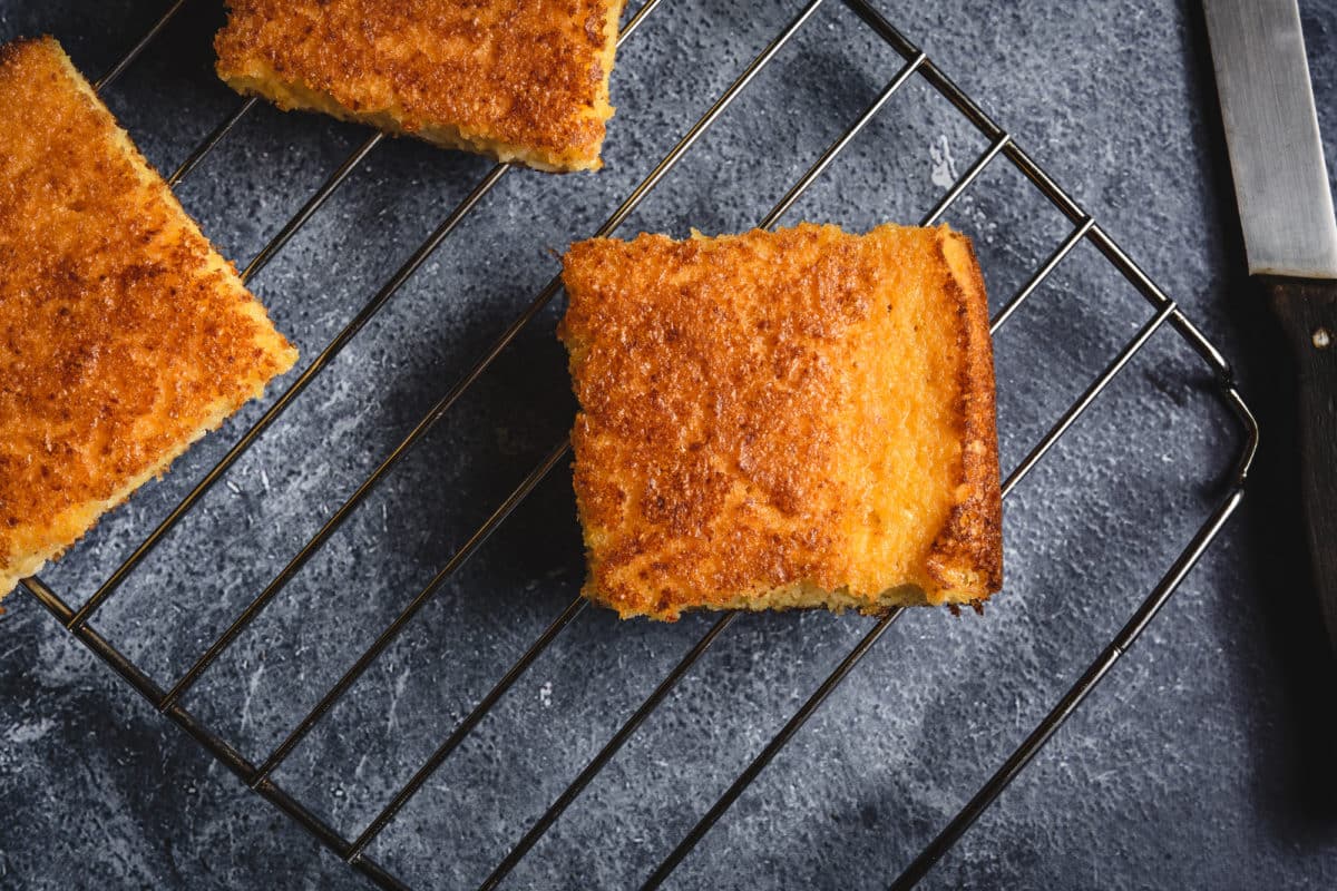 Slices of golden cornbread on a cooling rack.