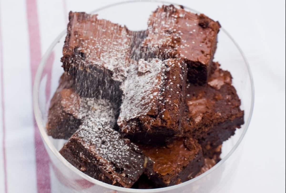 Moist gluten-free chocolate brownie with a dusting of powdered sugar.