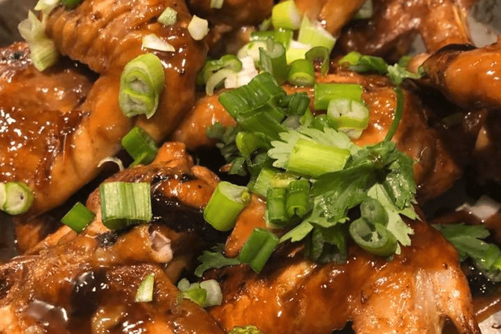 Grilled chicken wings glazed with a shiny sauce.