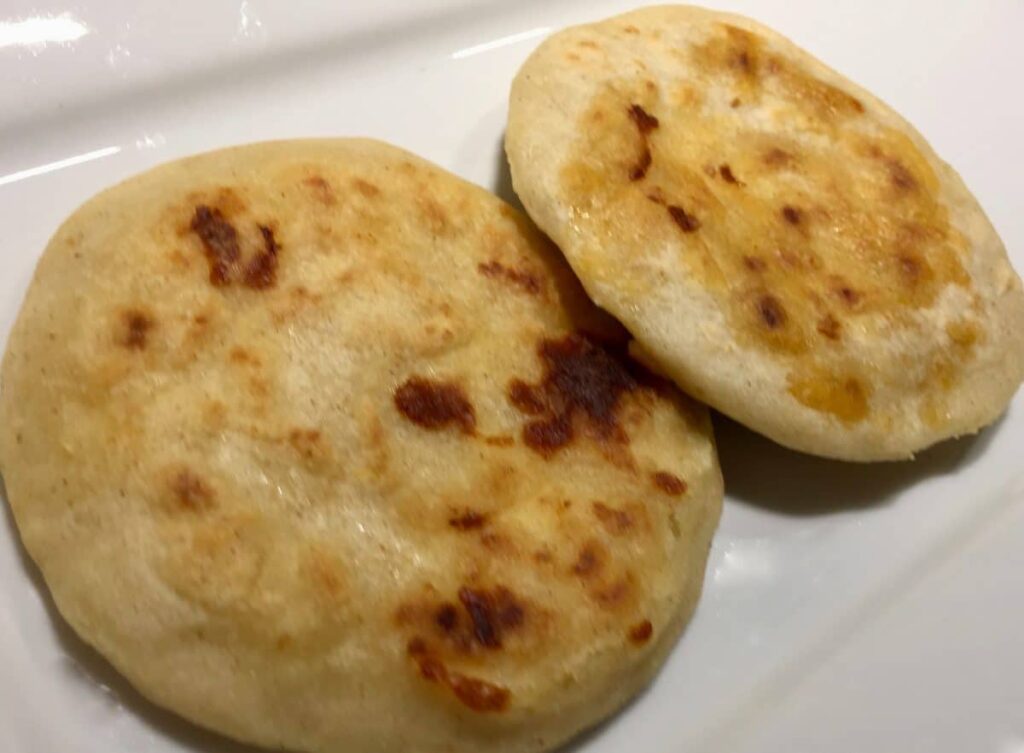 A perfectly grilled pupusa displayed on a plate