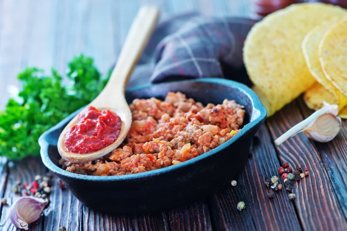 Skillet with ground meat, tomato sauce, and garlic