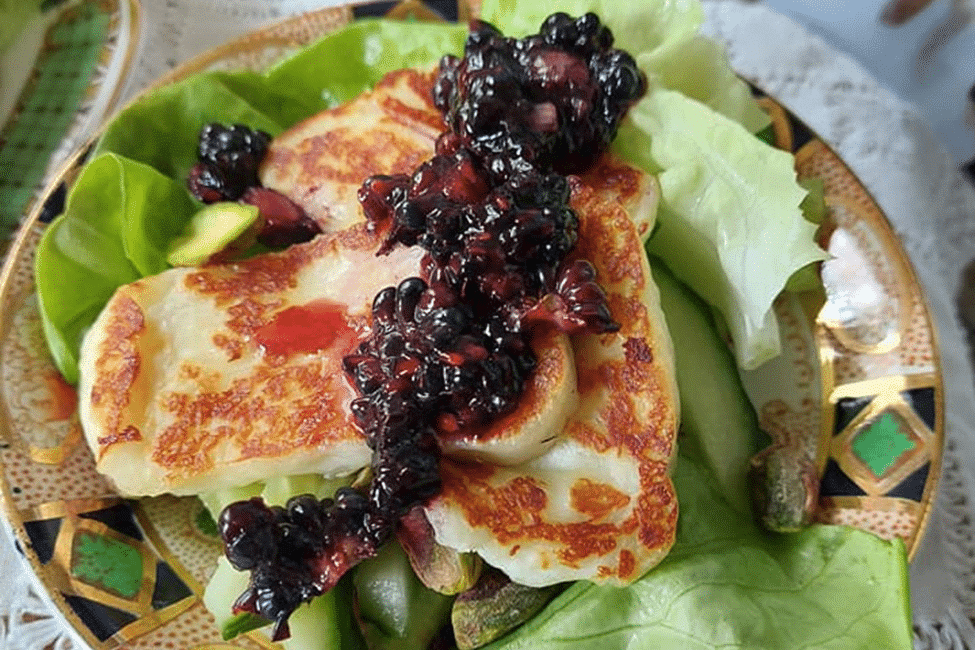 Pan-fried halloumi with a rich blackberry compote atop greens.