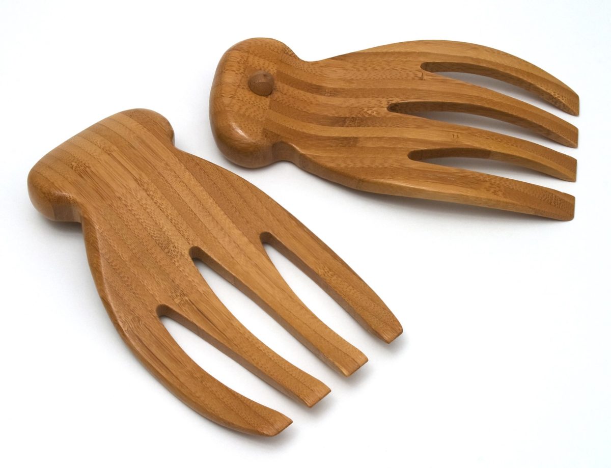 Wooden salad hands resting on a wooden surface.