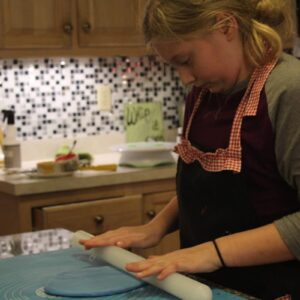 Young girl with her hands on a kitchen countertop.