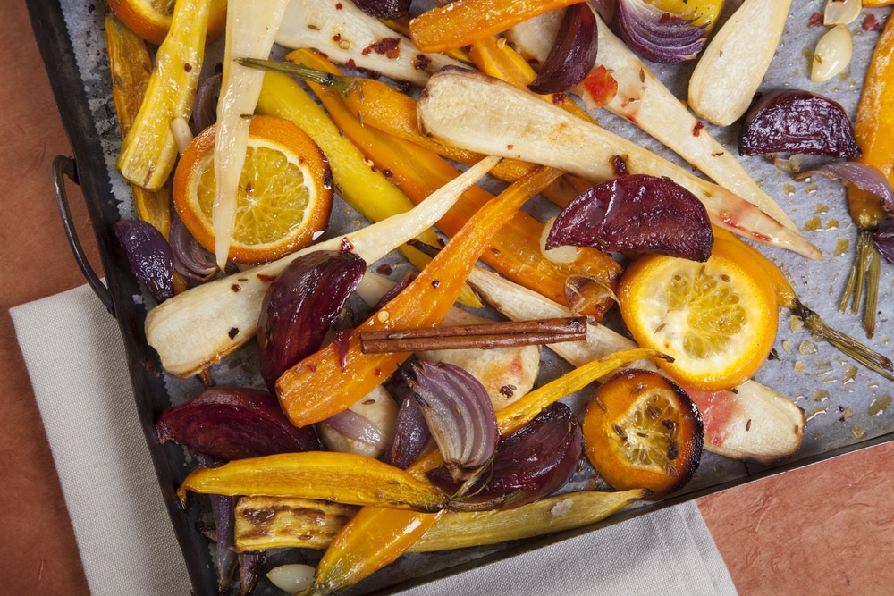 Oven-roasted assortment of colorful root vegetables with olive oil, herbs, and spices.