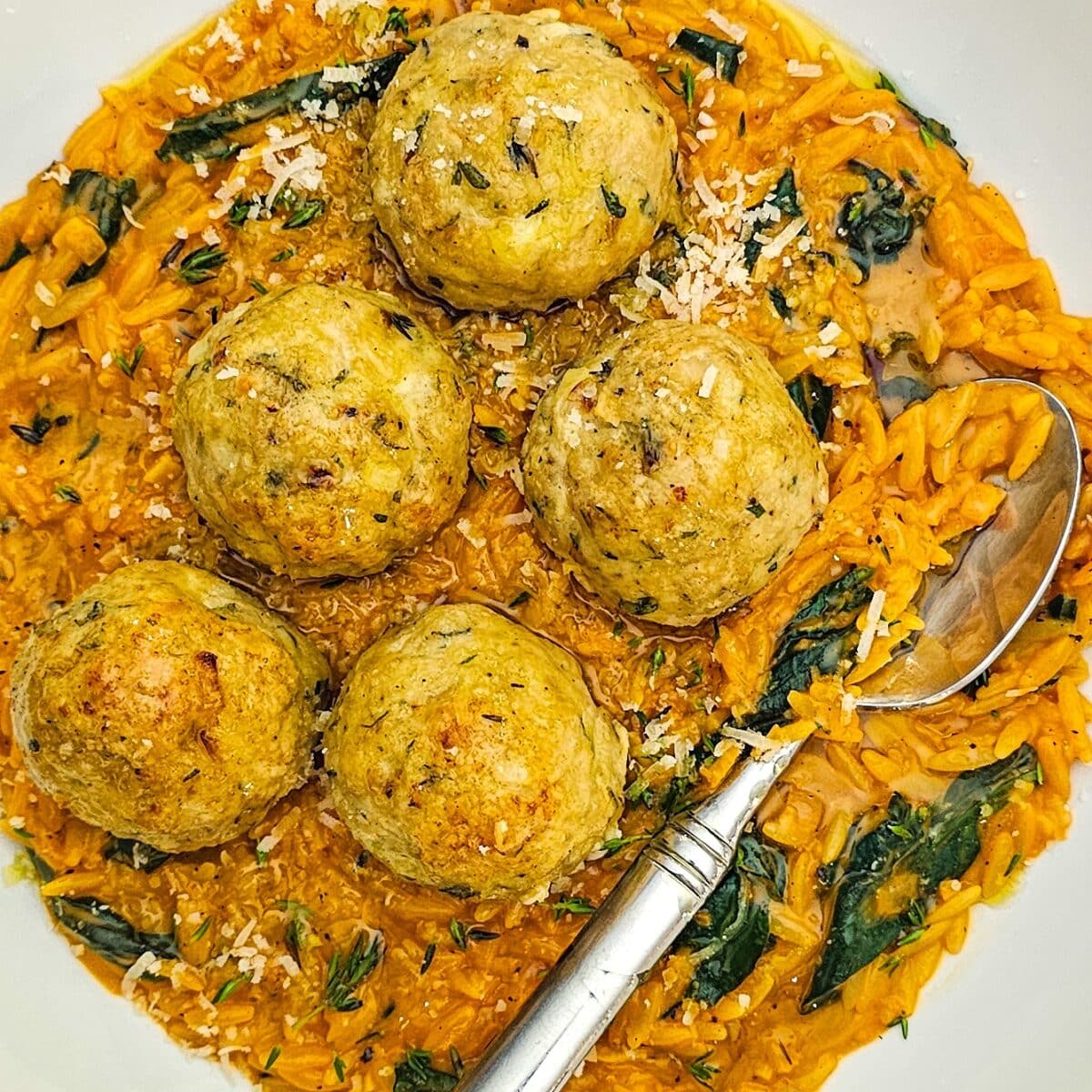 Herbed chicken meatballs on creamy tomato orzo and spinach