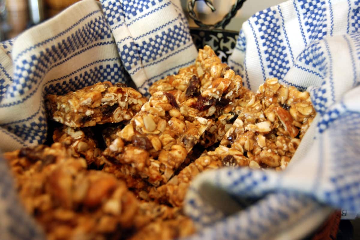 Bowl with a decorative towel containing homemade granola bars.