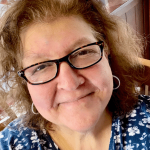Portrait of Jennifer Heftler with glasses and floral shirt
