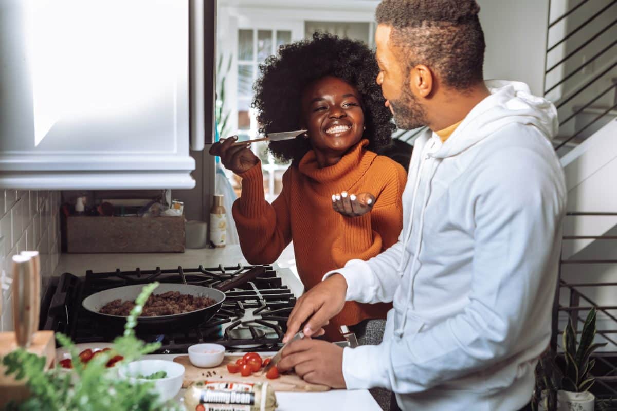 A couple joyfully cooking together in a modern kitchen