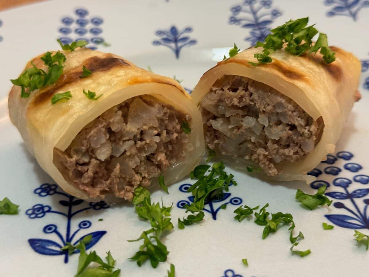 Kåldolmar (Swedish cabbage rolls) cut in half on a plate