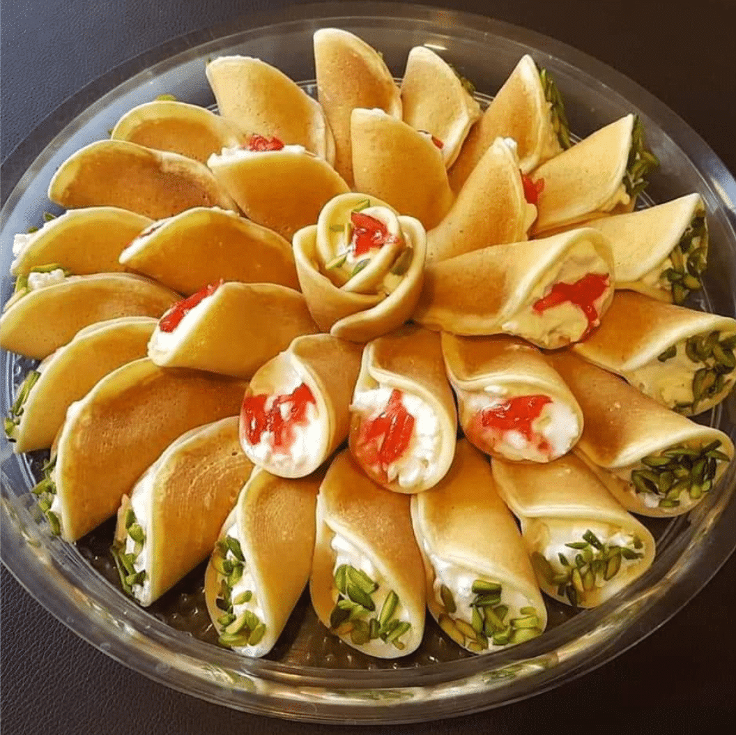 Filled Katayef Asafiri arranged in a circle with toppings.