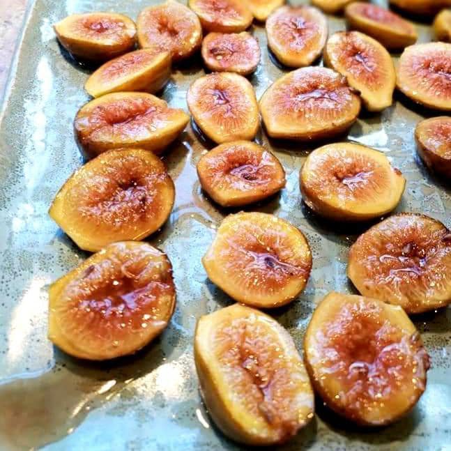Roasted figs with a hint of lavender on a tray.