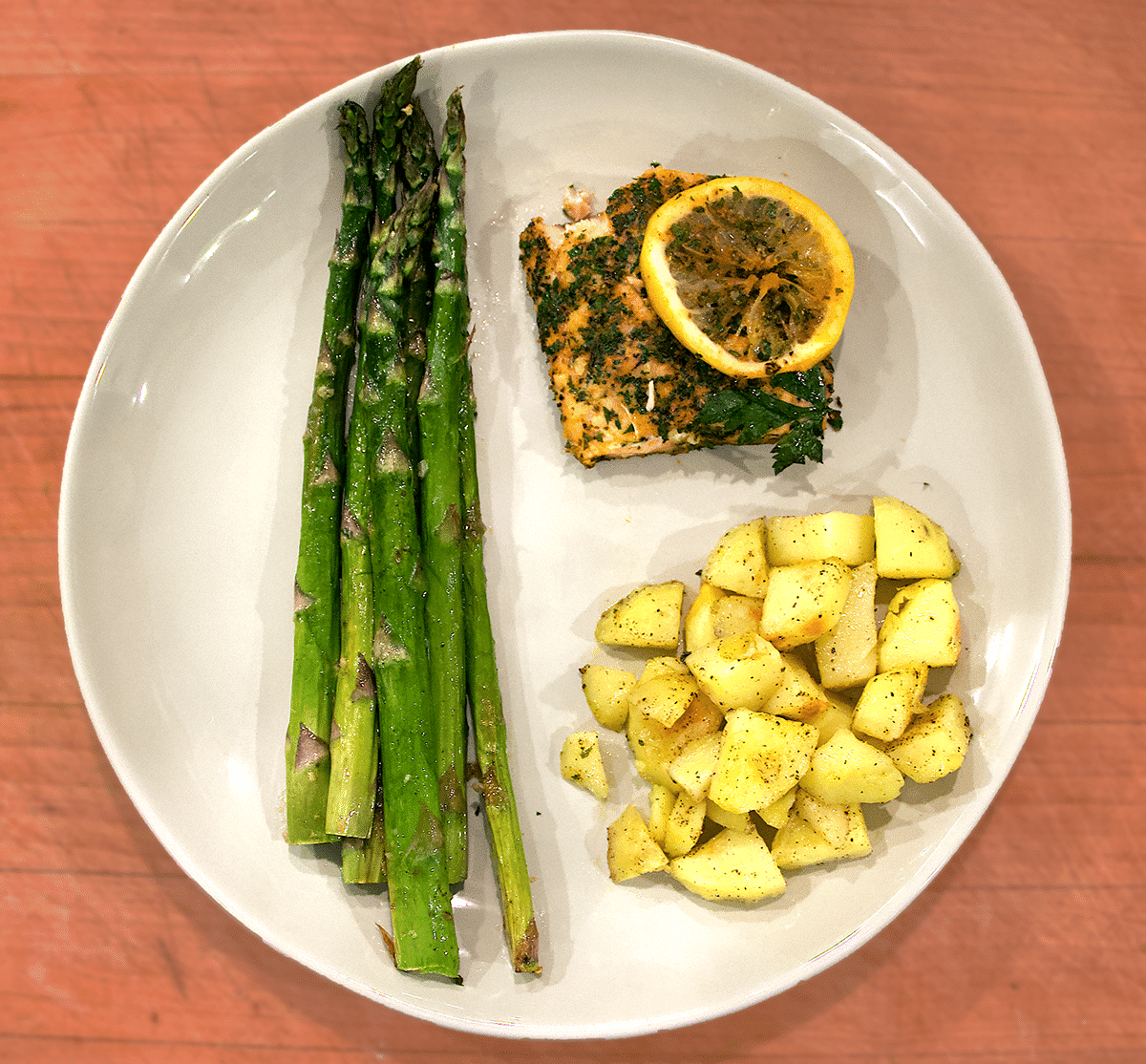 Plated dish of lemon salmon bake with asparagus and potatoes