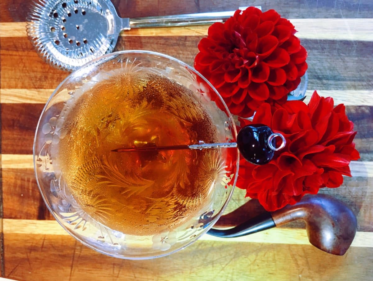 Cocktail with a red flower garnish