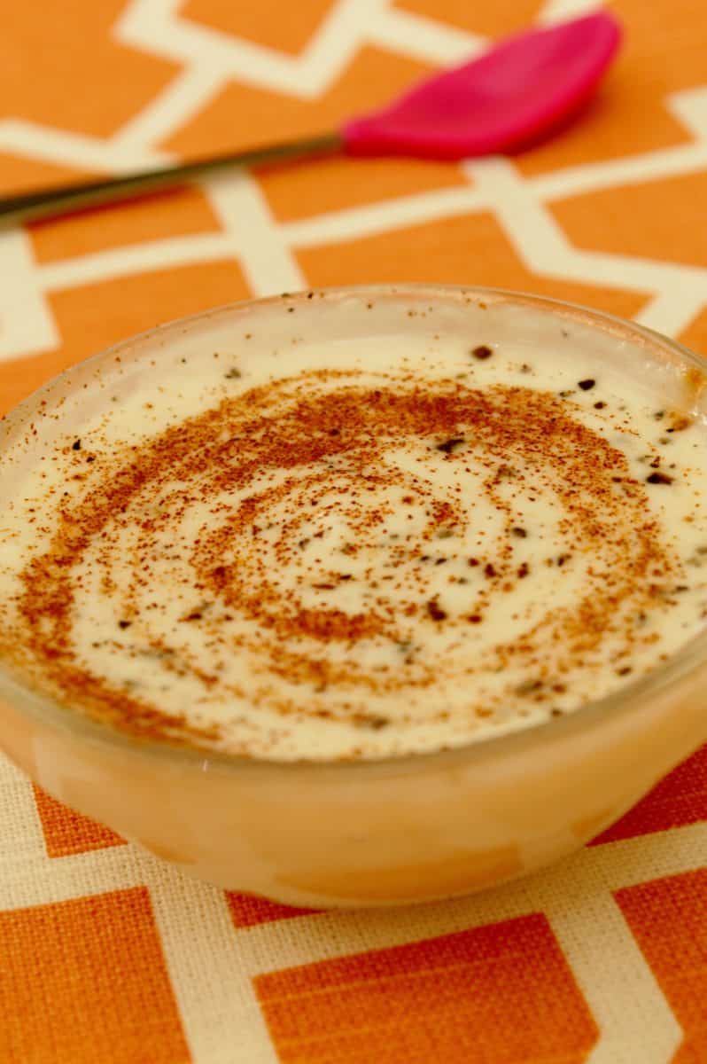 A bowl of Masala Chai Oatmeal with a sprinkle of spices on top.