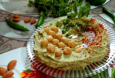 A plate of creamy hummus garnished with chickpeas and spices.