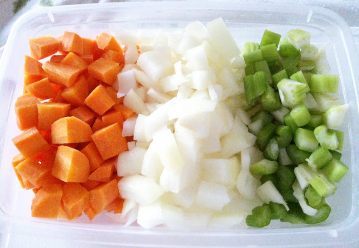 Diced onions, celery, and carrots, commonly known as mirepoix, prepared for cooking.